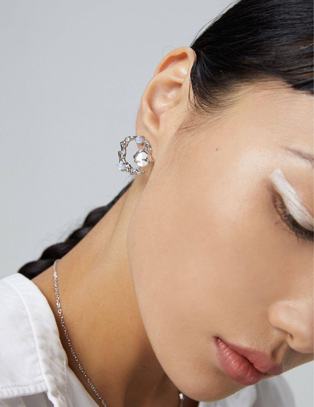 Close-up of model showcasing asymmetric earring design