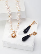 The camellia pendant layered with other delicate gold necklaces.
