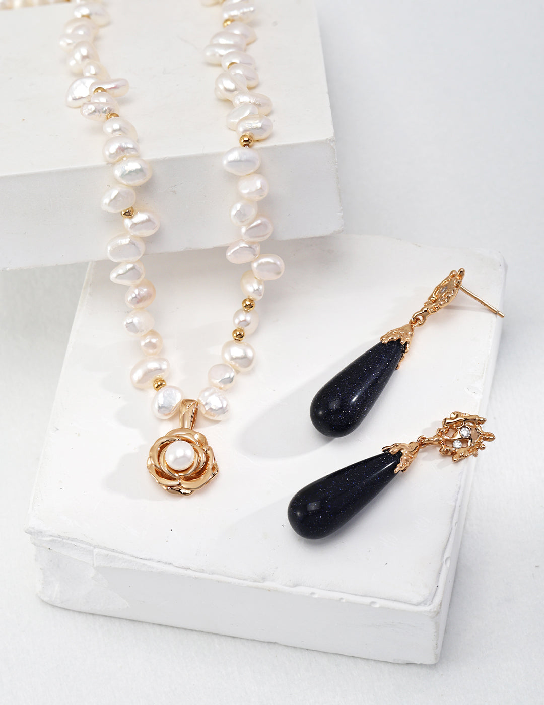 The camellia pendant layered with other delicate gold necklaces.