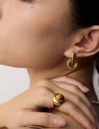 Model showcasing the detachable Tiger's Eye component worn as the second earring style.