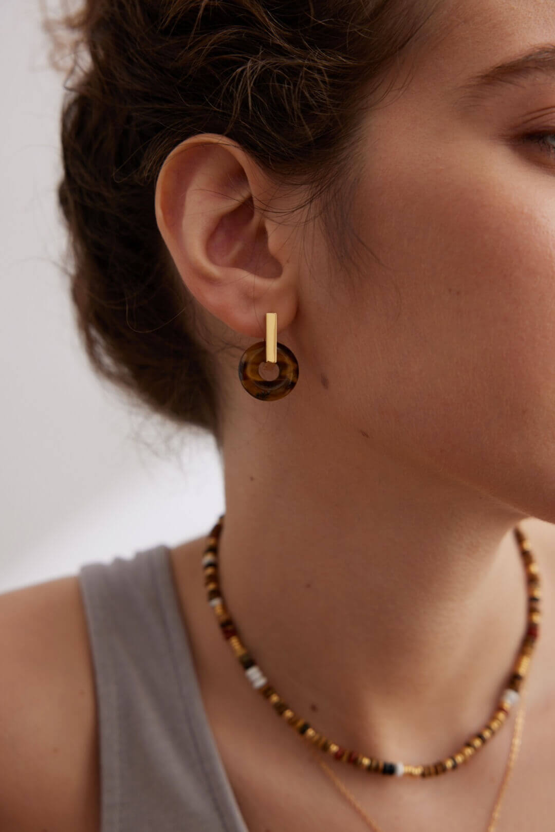 Model wearing the detached Tiger's Eye stone as a necklace pendant.