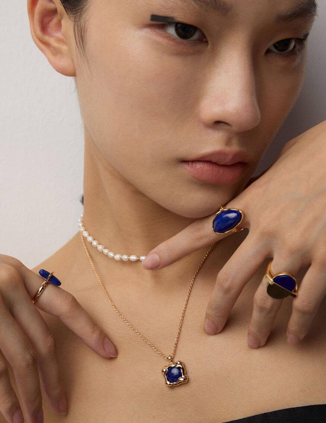 Close-up shot of lapis lazuli pendant resting on model's collarbone.