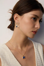 Detailed portrait focusing on the pendant necklace on model.
