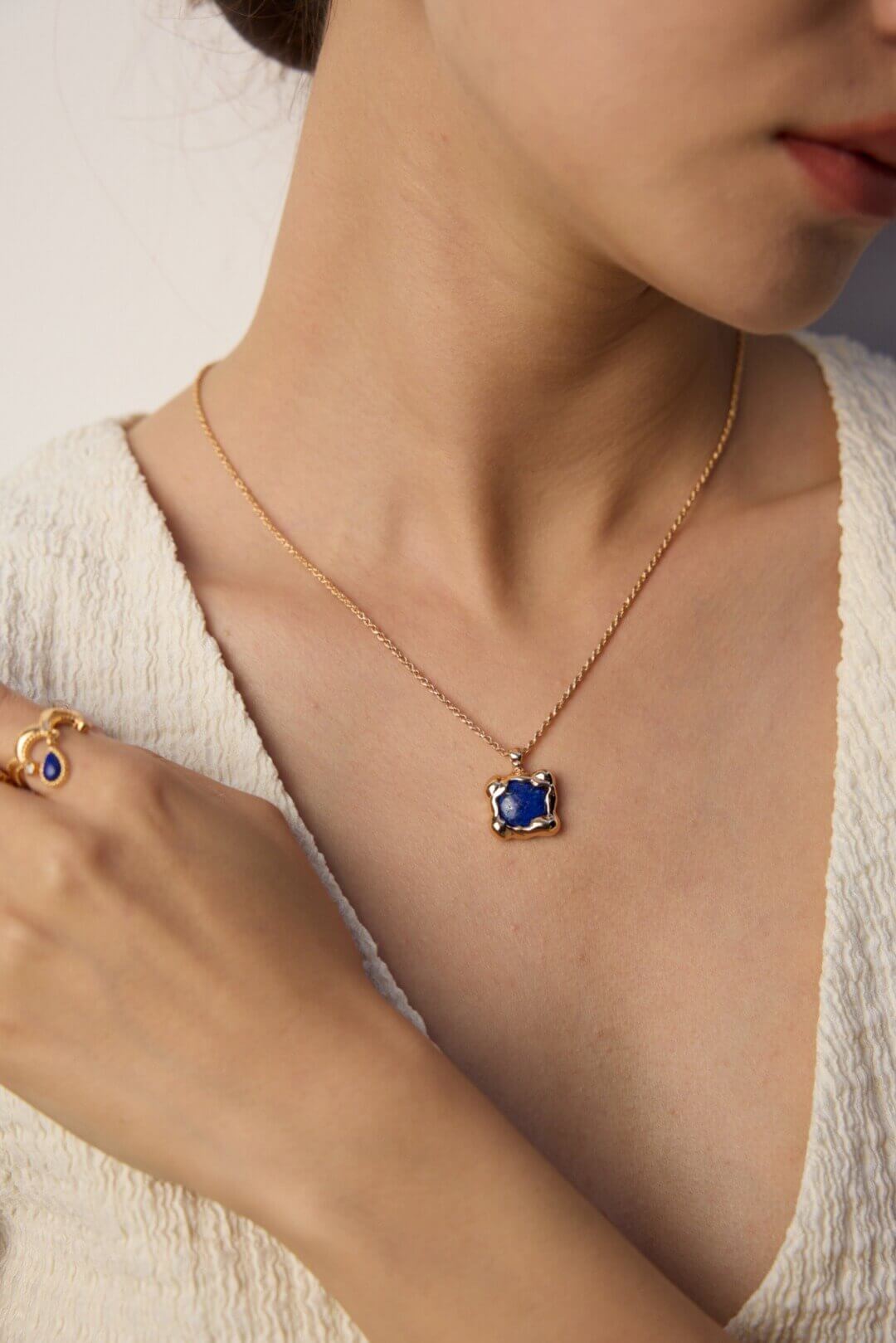 Lapis lazuli pendant layered with other delicate necklaces.