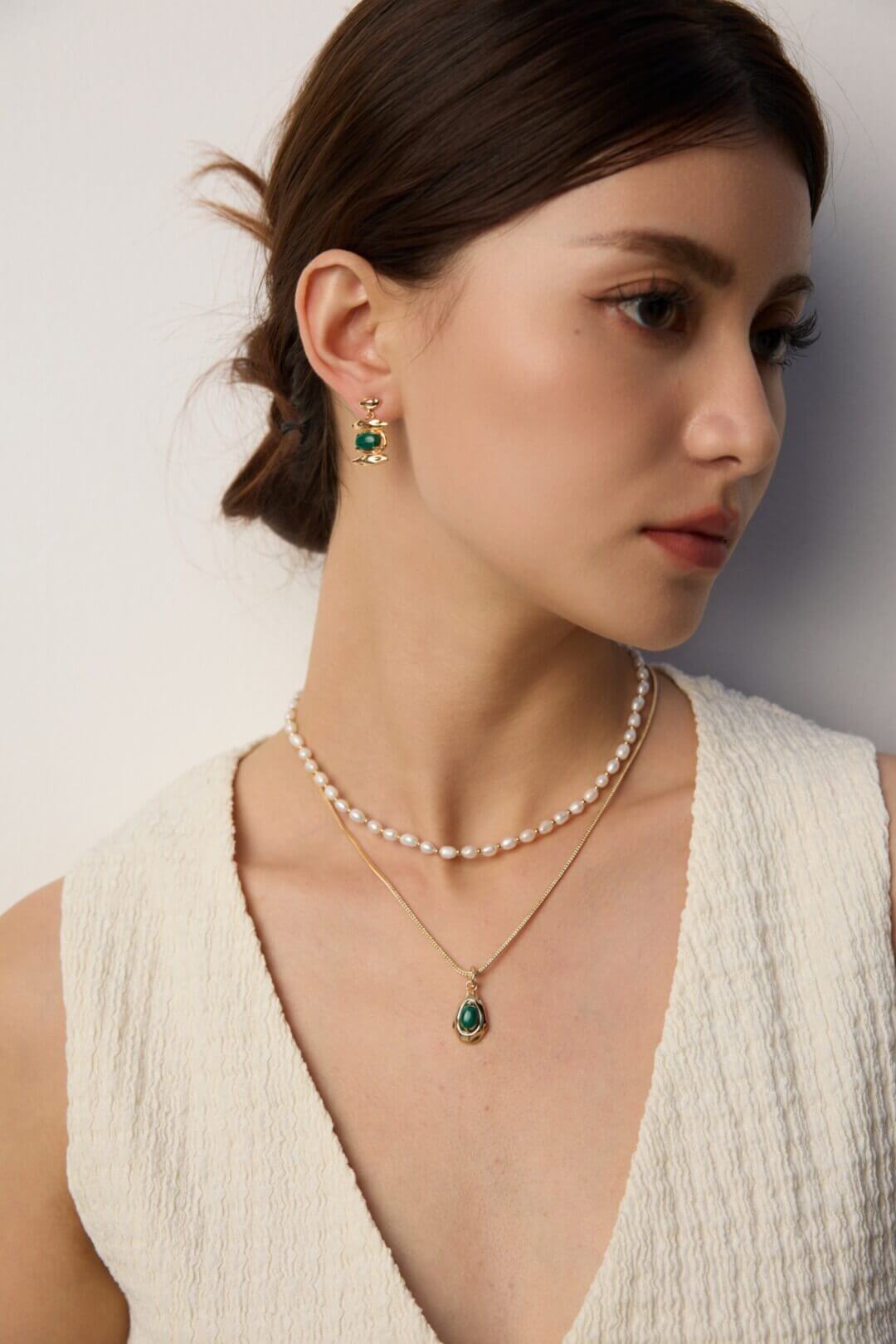 Female model wearing the malachite pendant necklace - close-up side view.