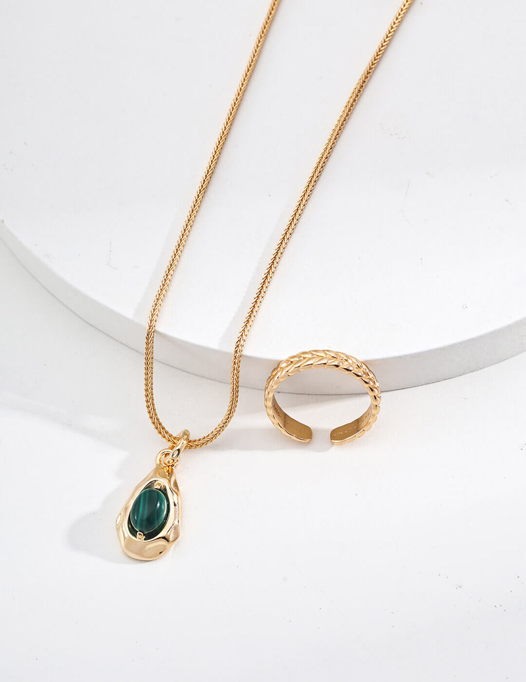 Model gently holding the malachite pendant, showcasing its size and detail.