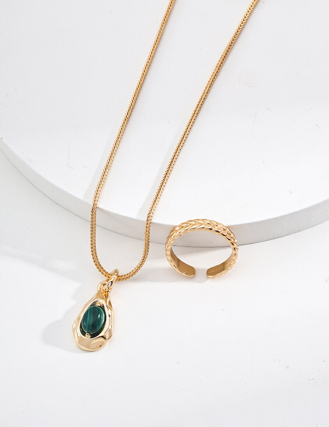 Model gently holding the malachite pendant, showcasing its size and detail.