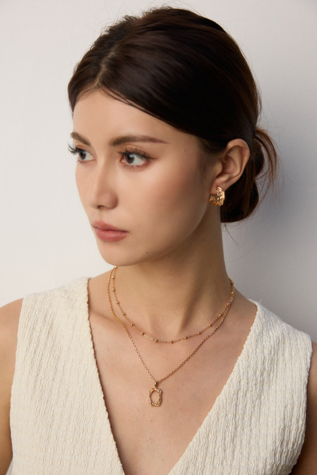 Professional woman wearing the simple textured necklace in a business setting.