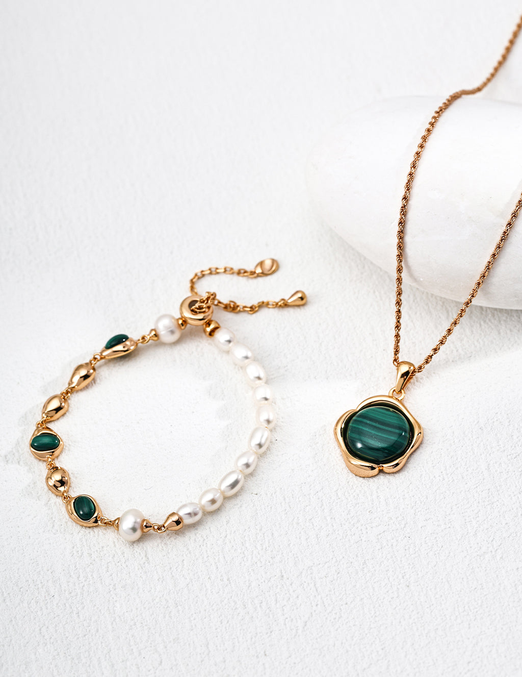 Close-up in natural light showing the pearl's luster and malachite's patterns.