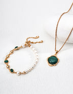 Close-up in natural light showing the pearl's luster and malachite's patterns.