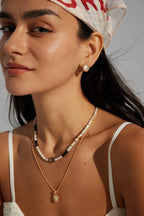 Female model wearing the minimalist shell stud earrings - close-up side view.