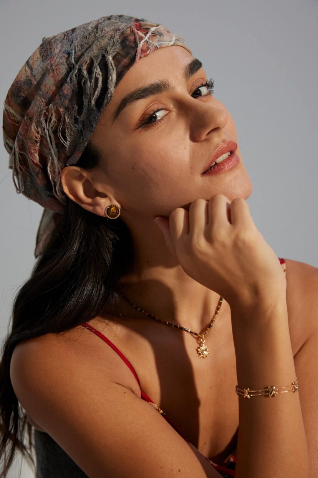 Young woman showcasing Tiger's Eye earrings with casual daytime outfit.