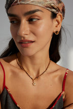 Model wearing Tiger's Eye stud earrings in soft natural sunlight.