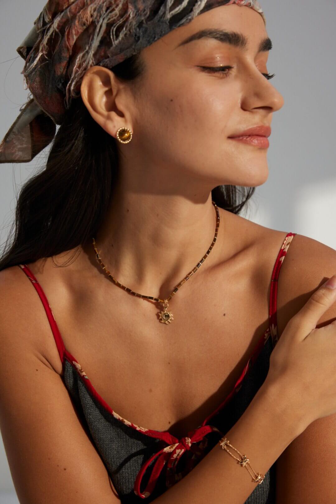 Professional woman wearing Tiger's Eye studs in office environment.