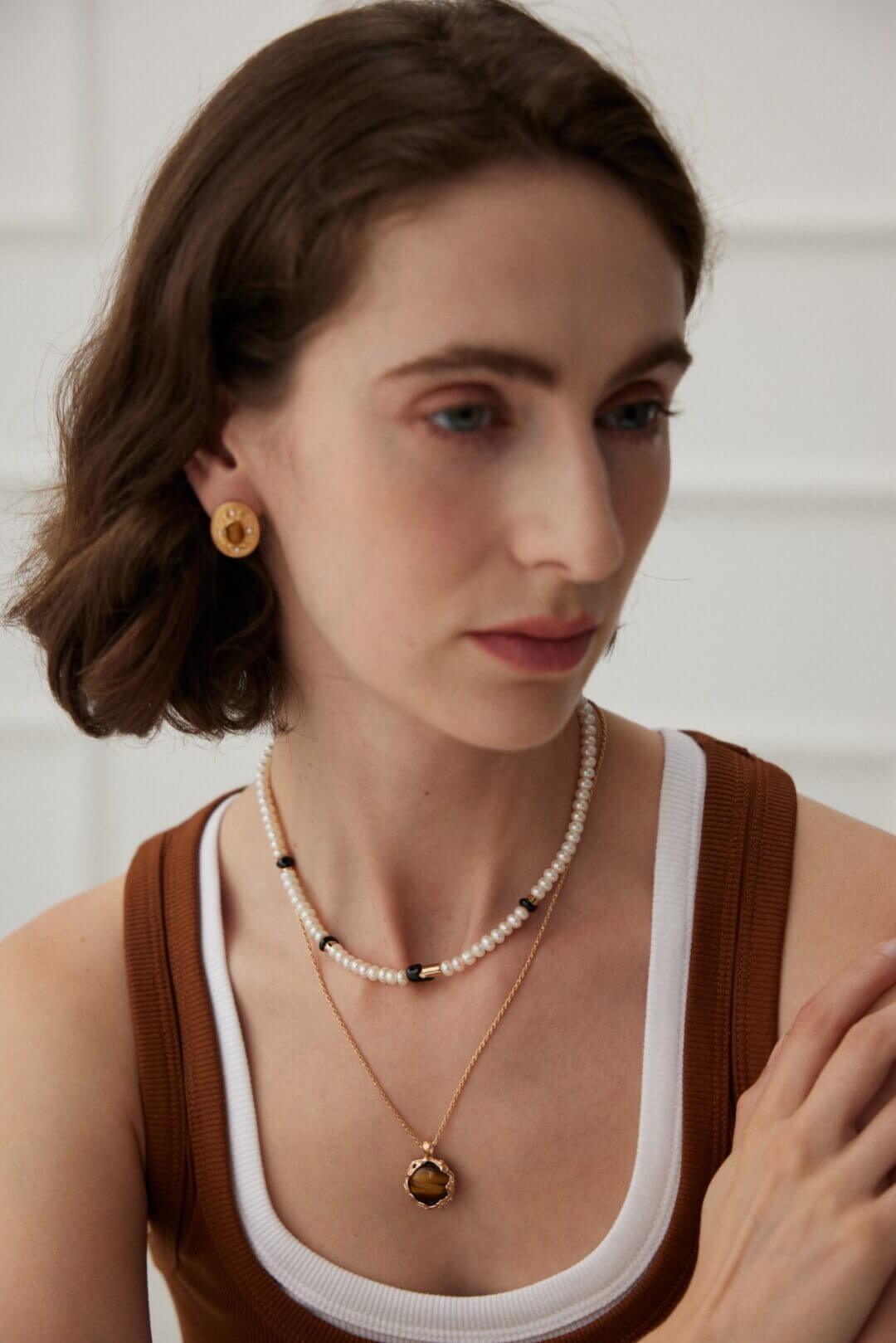 Woman wearing the hand-carved volcanic texture tiger's eye pendant.