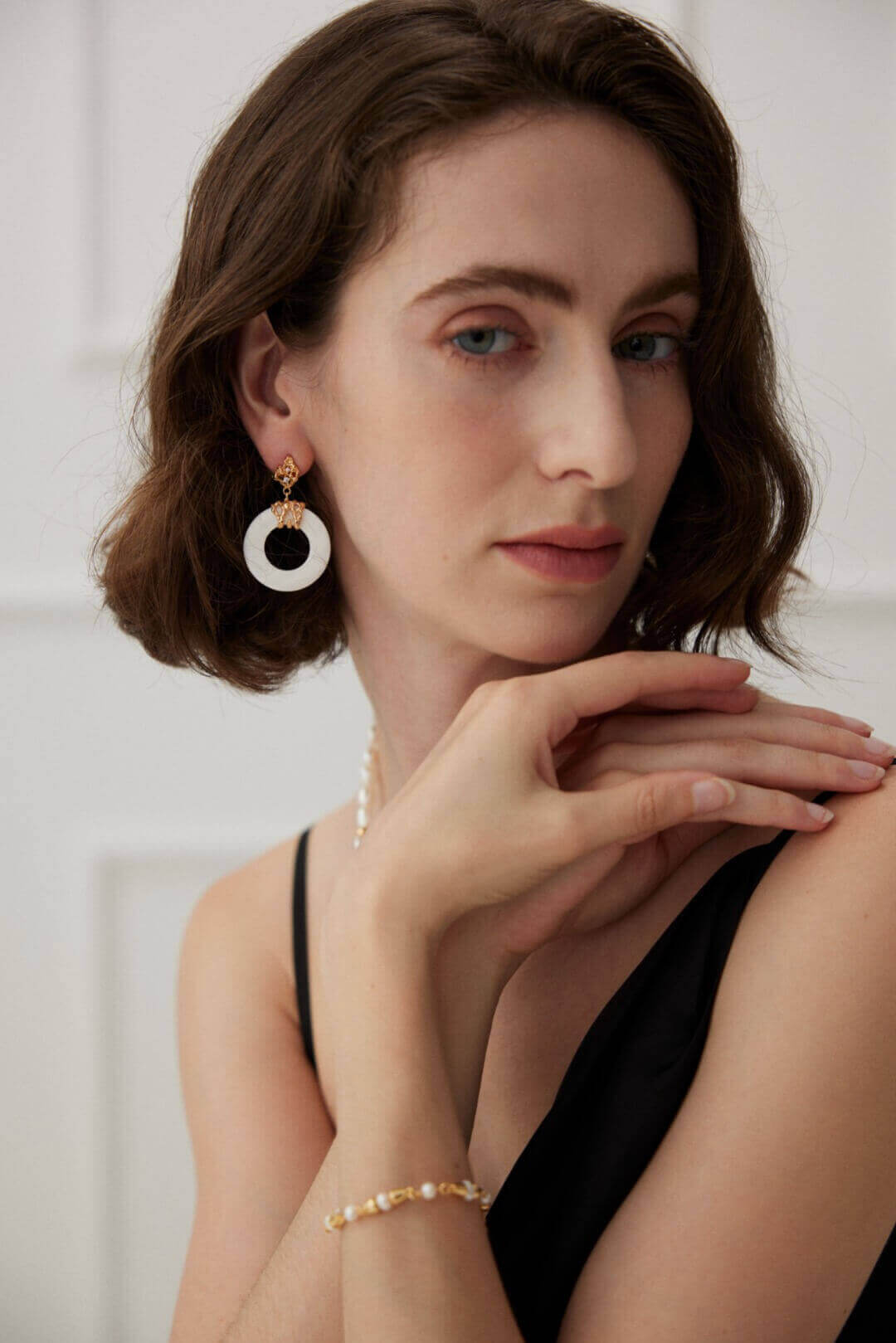 Natural white mother of pearl shell showcasing its soft iridescent luster through the minimalist openwork design.