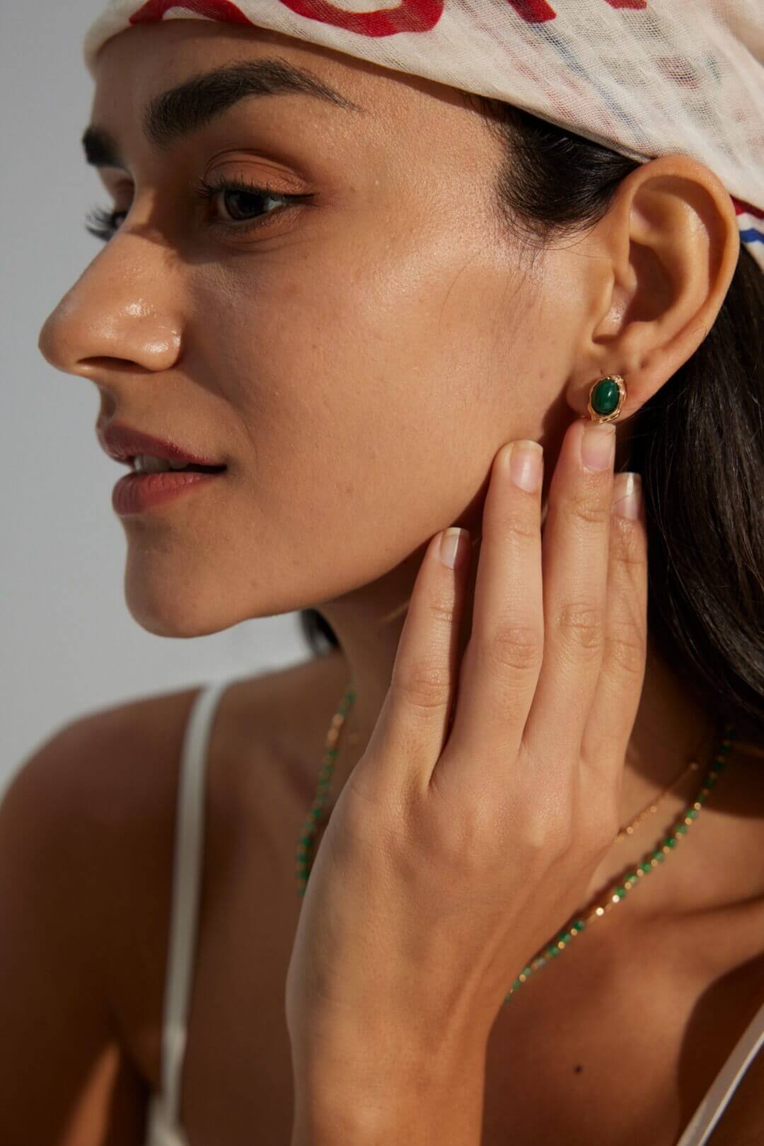 A pair of natural malachite stud earrings beautifully arranged together.