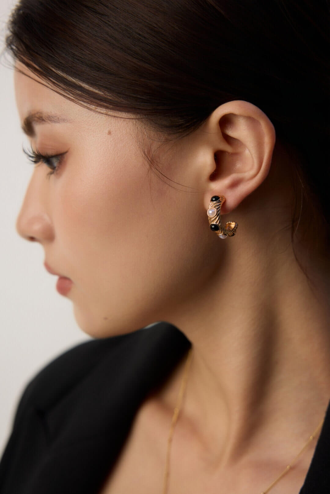 Close-up contrast of organic natural pearl luster against sleek black onyx in vintage stud earrings.