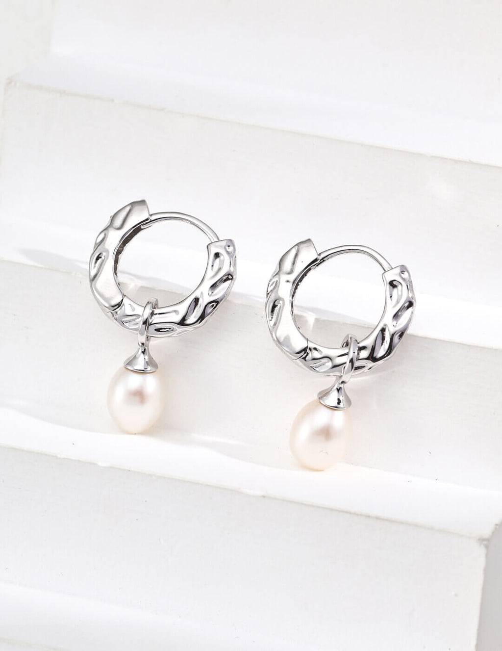 Natural pearl with soft iridescent luster, beautifully accented against the vintage wood grain texture.