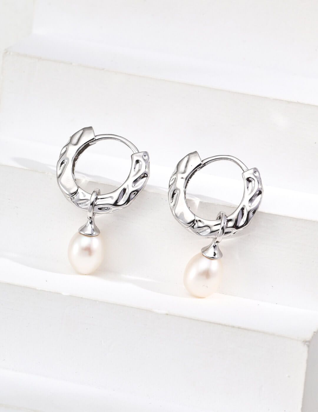 Natural pearl with soft iridescent luster, beautifully accented against the vintage wood grain texture.