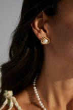 The pearl earrings styled with a matching pearl necklace.