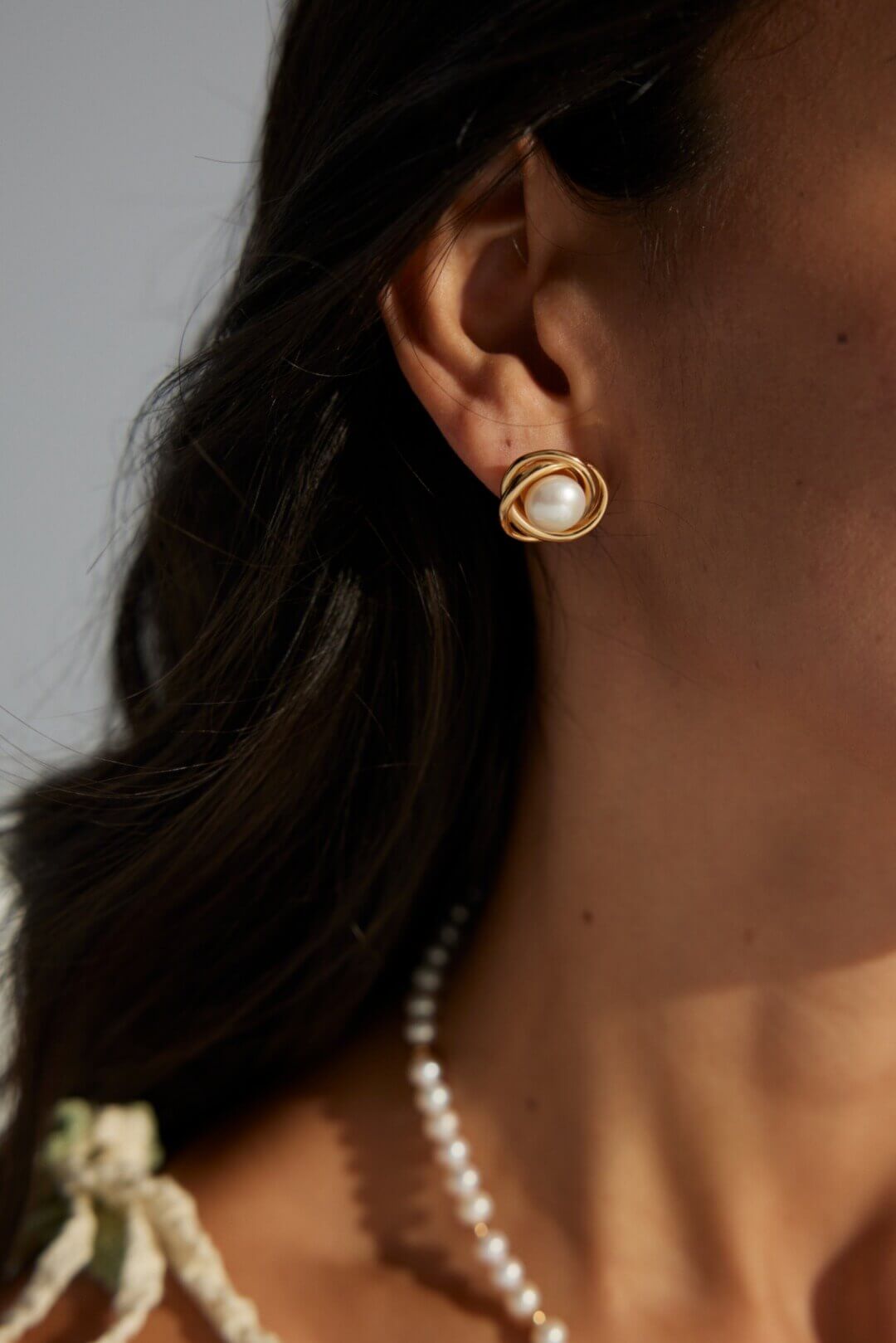 The pearl earrings styled with a matching pearl necklace.