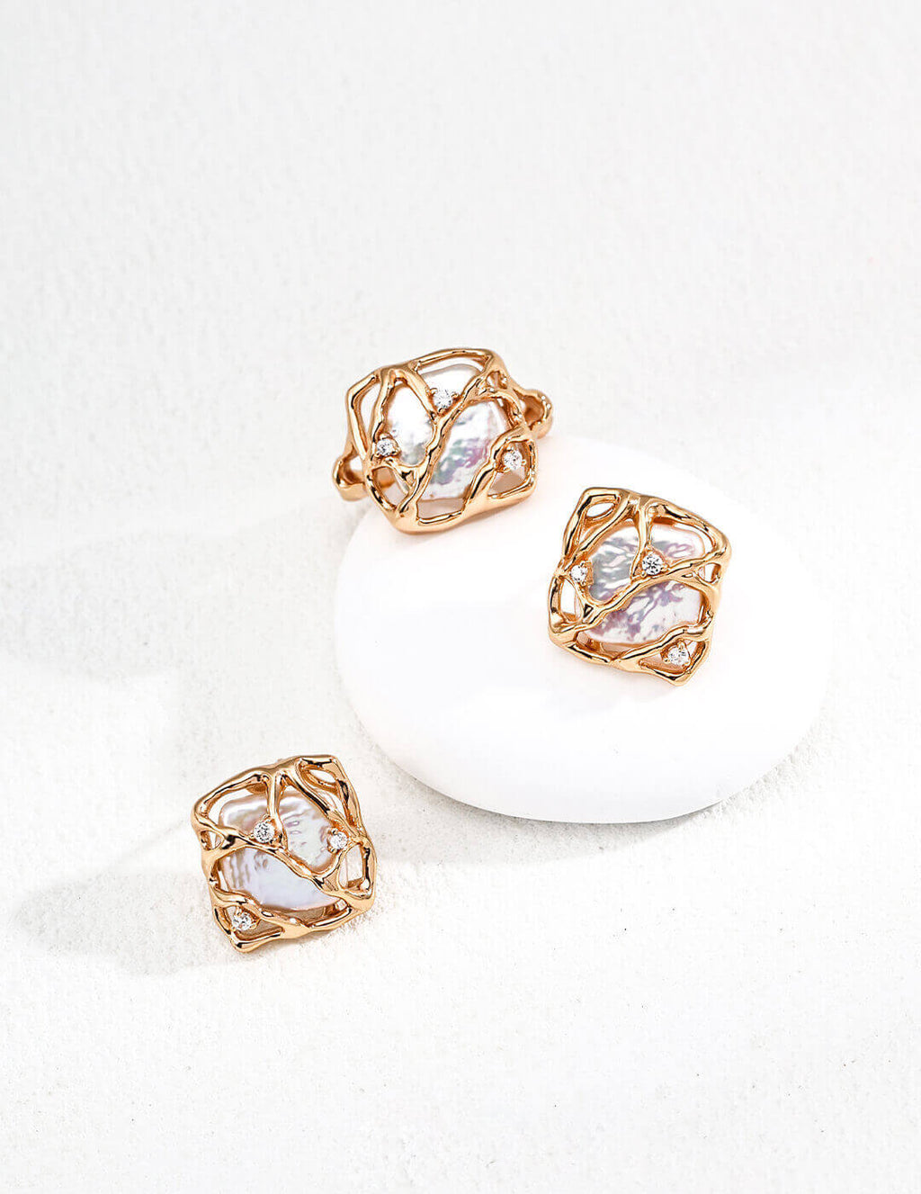 Rose gold earrings with clear gemstones on a white background