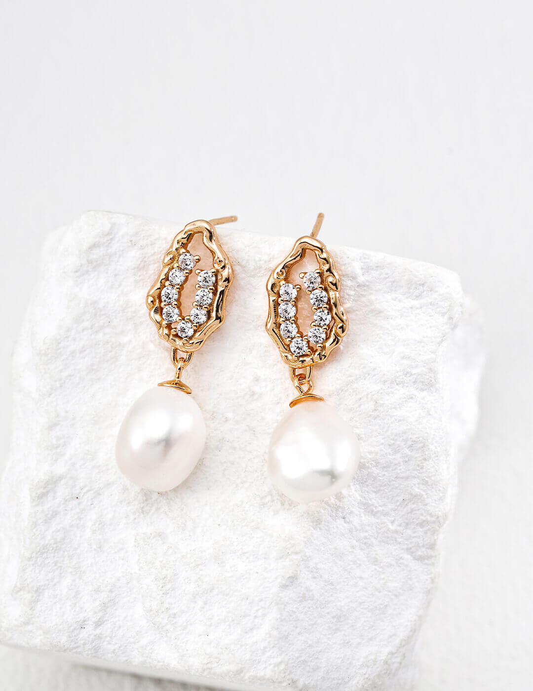 Front view of natural pearl and zircon drop earrings in vintage gold
