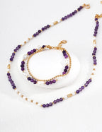 Purple beaded necklace and bracelet set on a white background