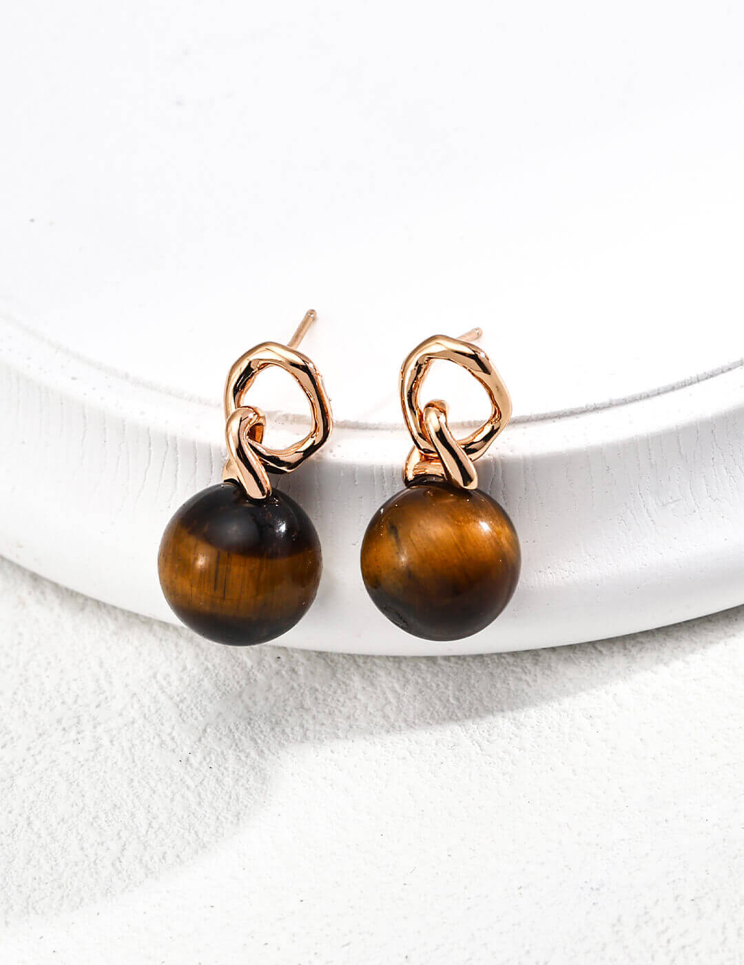 view showing secure French hook closure of tiger's eye drop earrings.