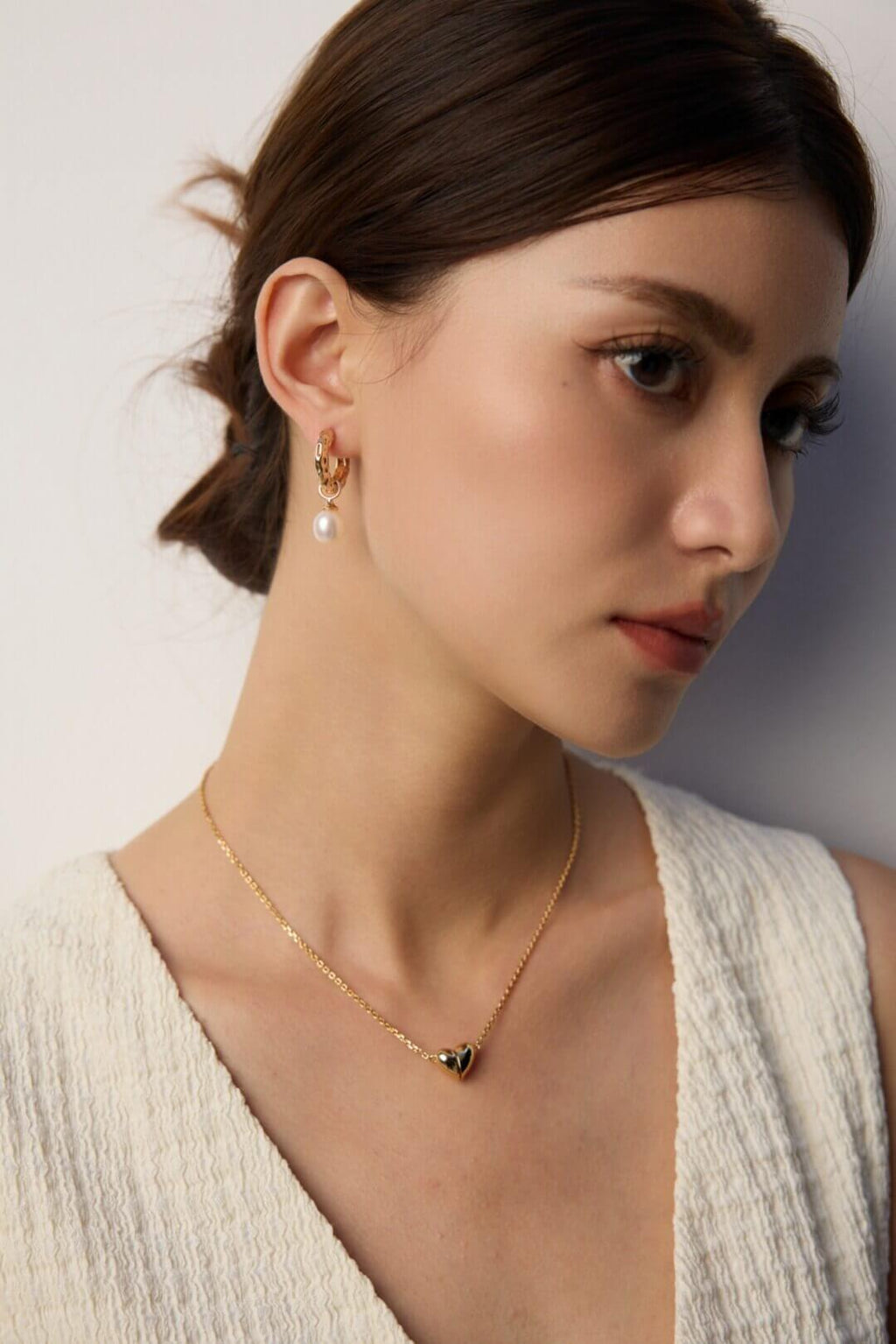 Model wearing the wood grain and pearl earrings in natural sunlight, evoking the beauty and warmth of nature.