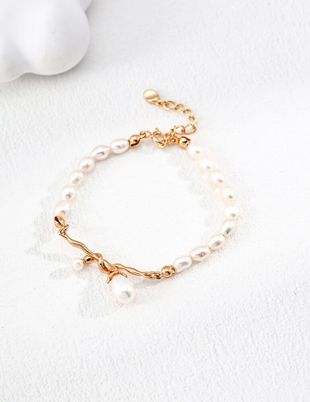 Pearl bracelet with gold accents on a white background
