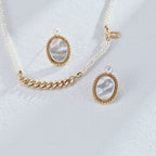 Minimalist pearl and shell earrings held in hand to show perfect size and delicate proportion for everyday elegance.