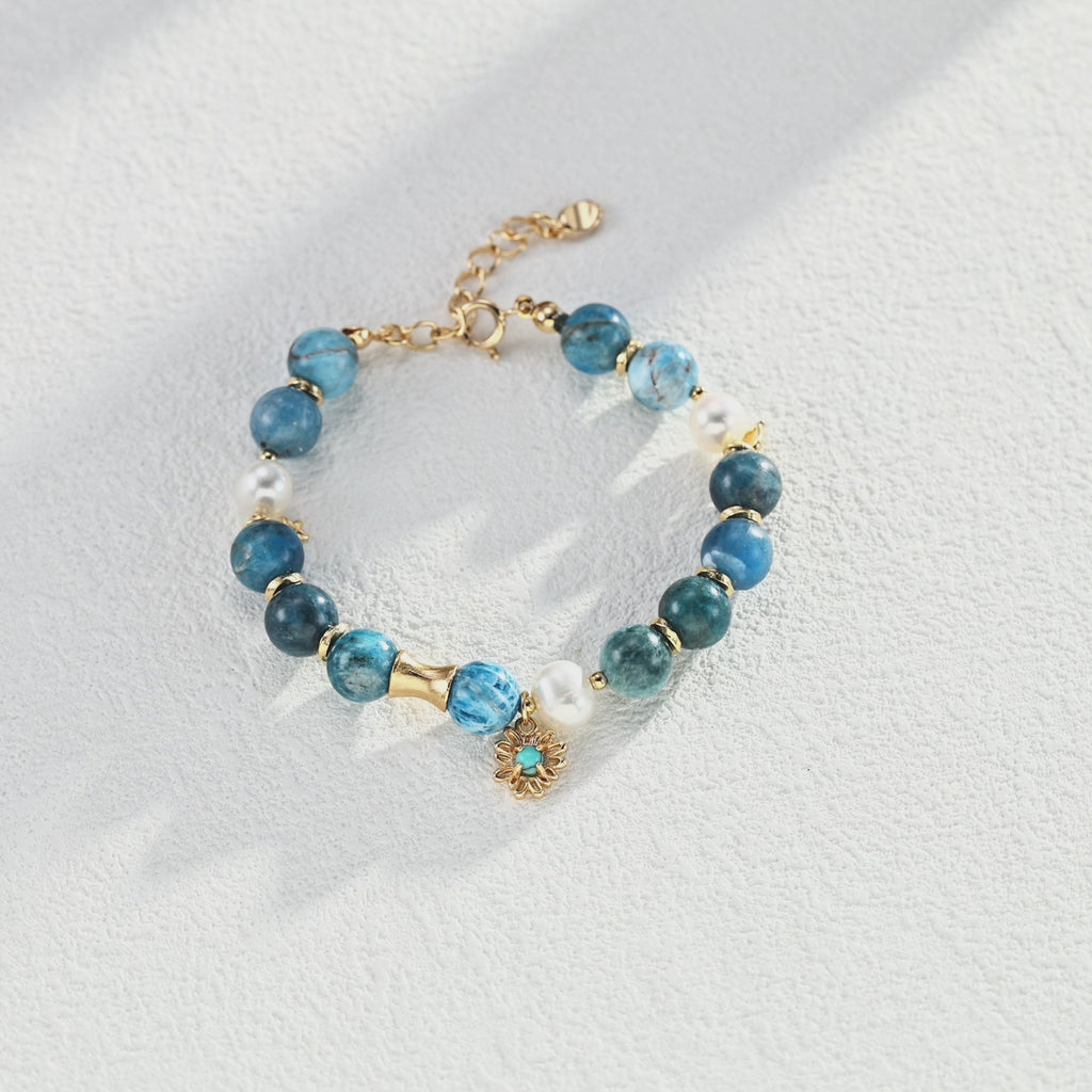 Flat lay arrangement of the entire Blue Harmony Jewelry Series, including necklace, earrings, bracelet, and ring against a neutral background