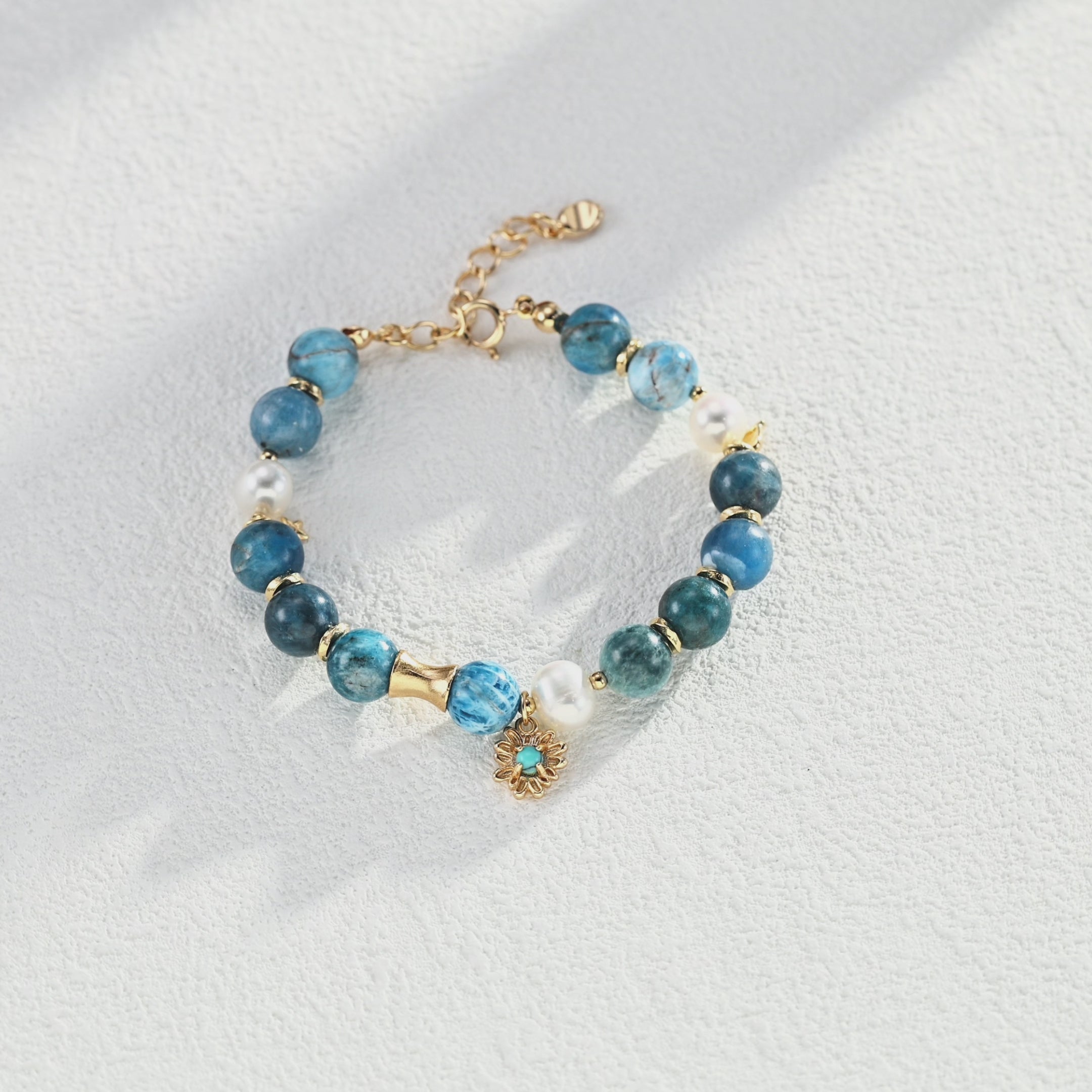 Flat lay arrangement of the entire Blue Harmony Jewelry Series, including necklace, earrings, bracelet, and ring against a neutral background