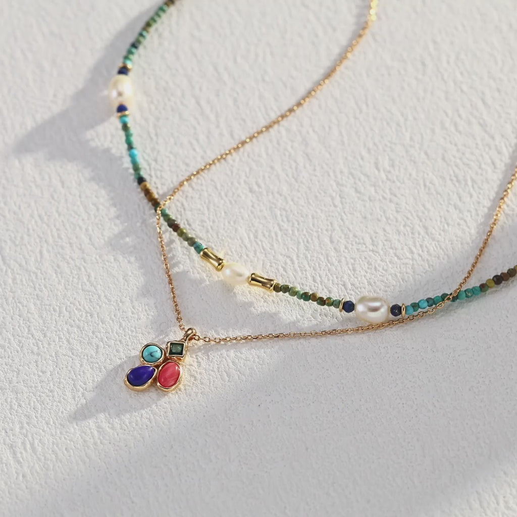 The multi-gemstone pendant layered with other delicate gold chains for a trendy look.