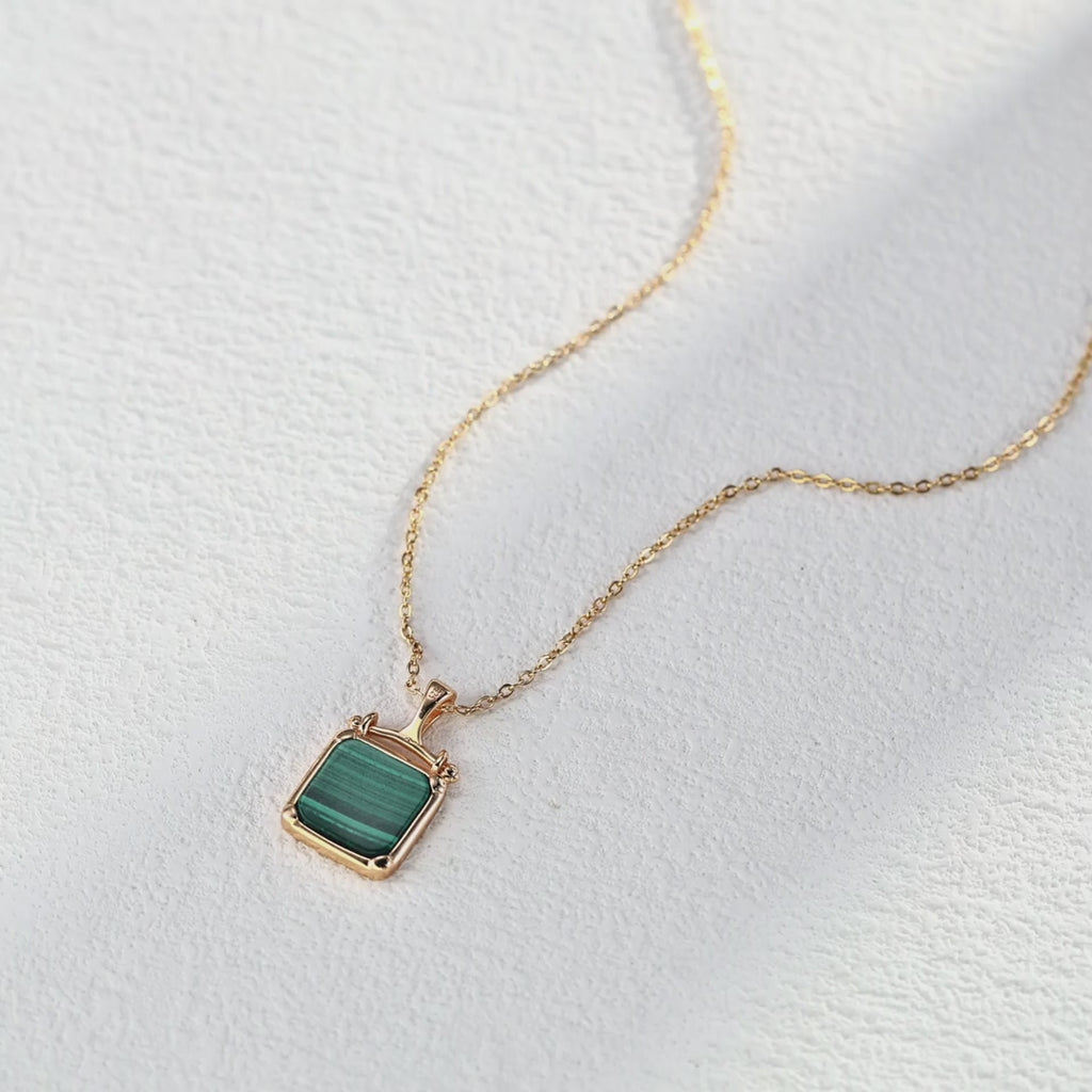 Malachite pendant necklace shown in hand to demonstrate perfect size and elegant proportions.