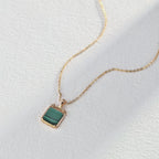 Malachite pendant necklace shown in hand to demonstrate perfect size and elegant proportions.