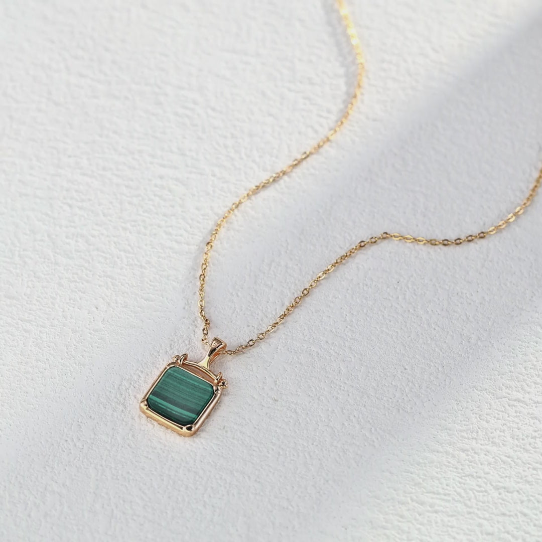 Malachite pendant necklace shown in hand to demonstrate perfect size and elegant proportions.