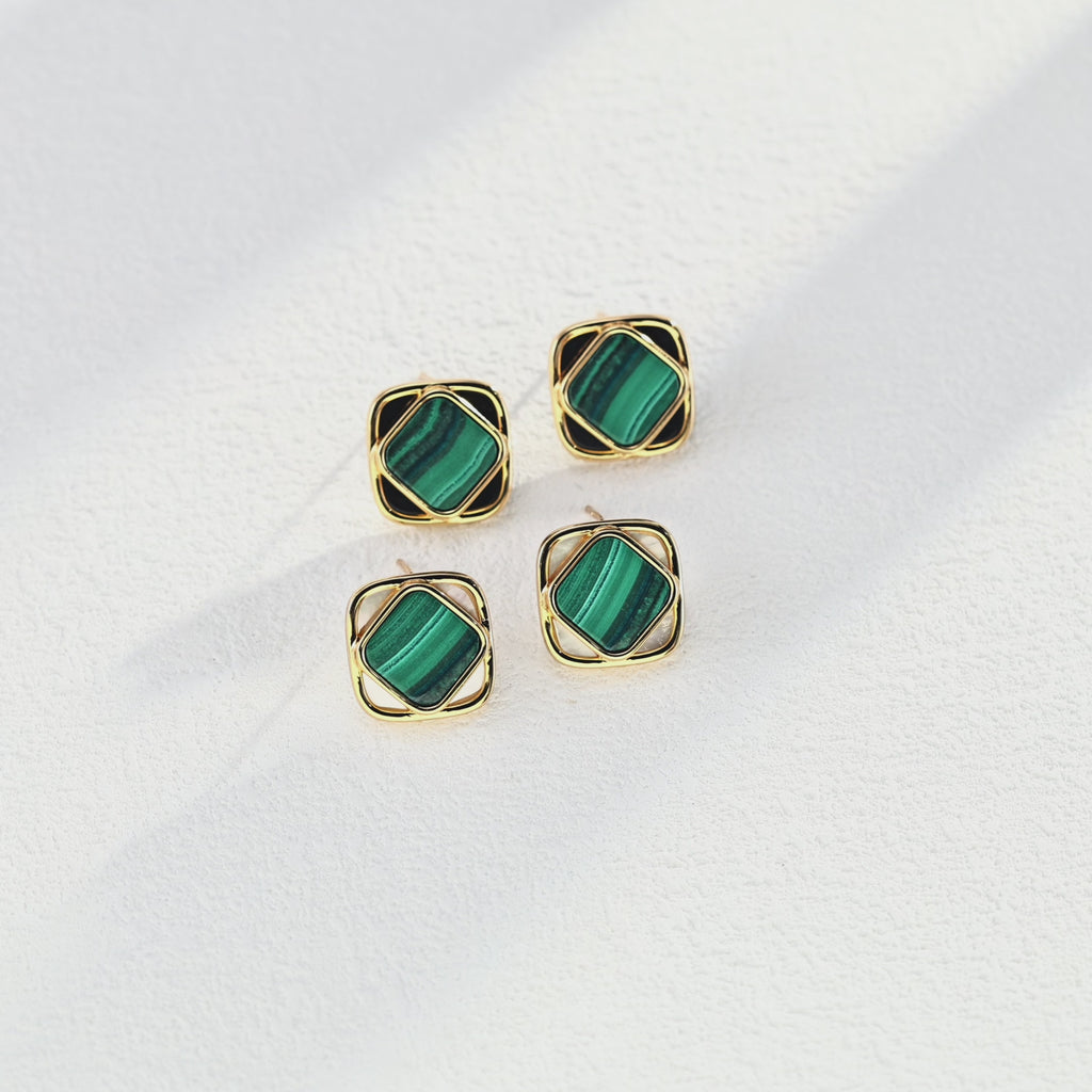 The green malachite and white shell earrings catching the light, showcasing their natural luster and fresh, vibrant colors.