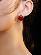Side view of red enamel drop earrings on model, showcasing the 17mm elegant drop and vibrant color.