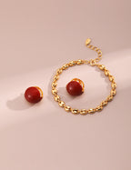 Red enamel drop earrings catching light to showcase vibrant color and K gold plating luster.