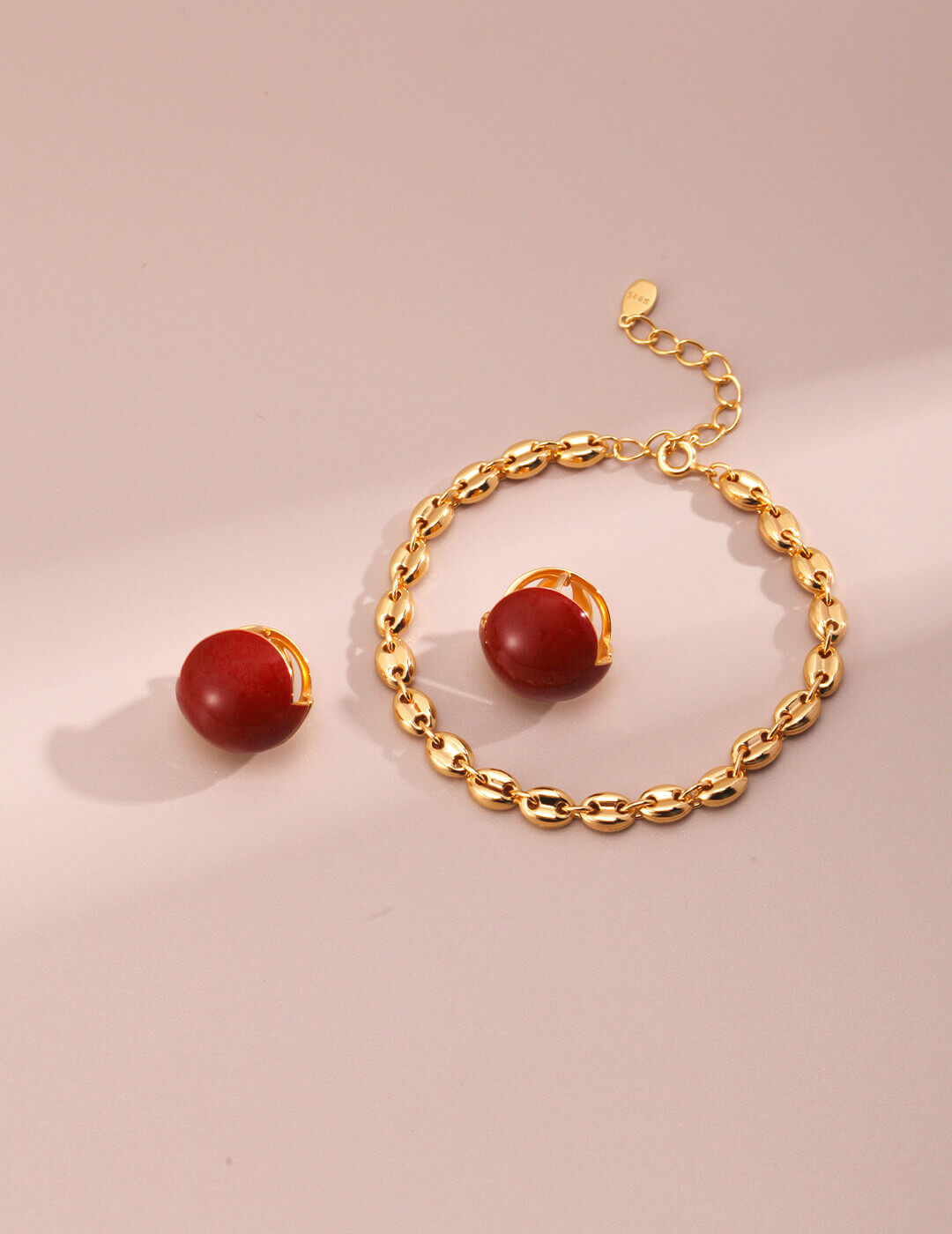 Red enamel drop earrings catching light to showcase vibrant color and K gold plating luster.