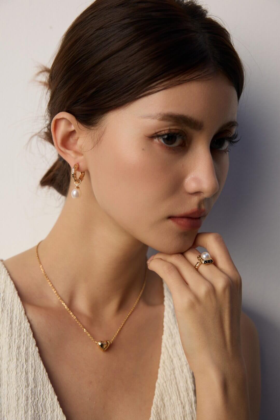 Side view of the retro wood grain and pearl earrings on a model's ear, showcasing the elegant and graceful silhouette.