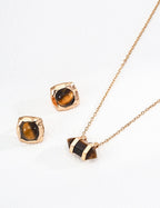 Gold necklace and earrings with tiger's eye stones on a white background
