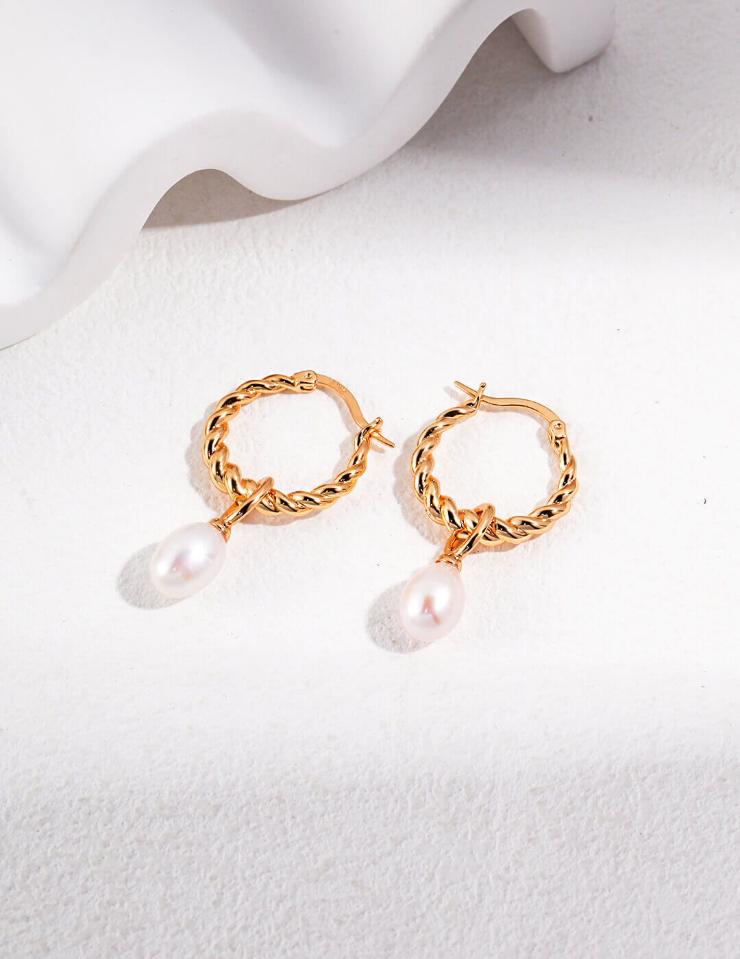 Natural pearl drop earrings in warm vintage gold plating.