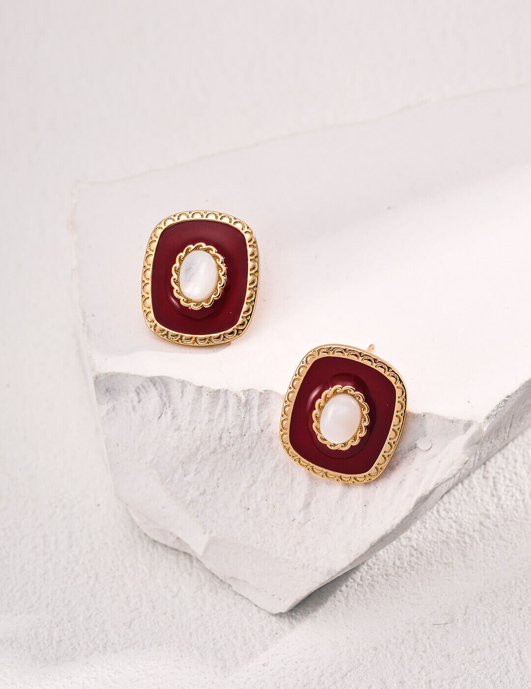 Close-up of the white shell pendant with a soft moonlight glow in these minimalist earrings