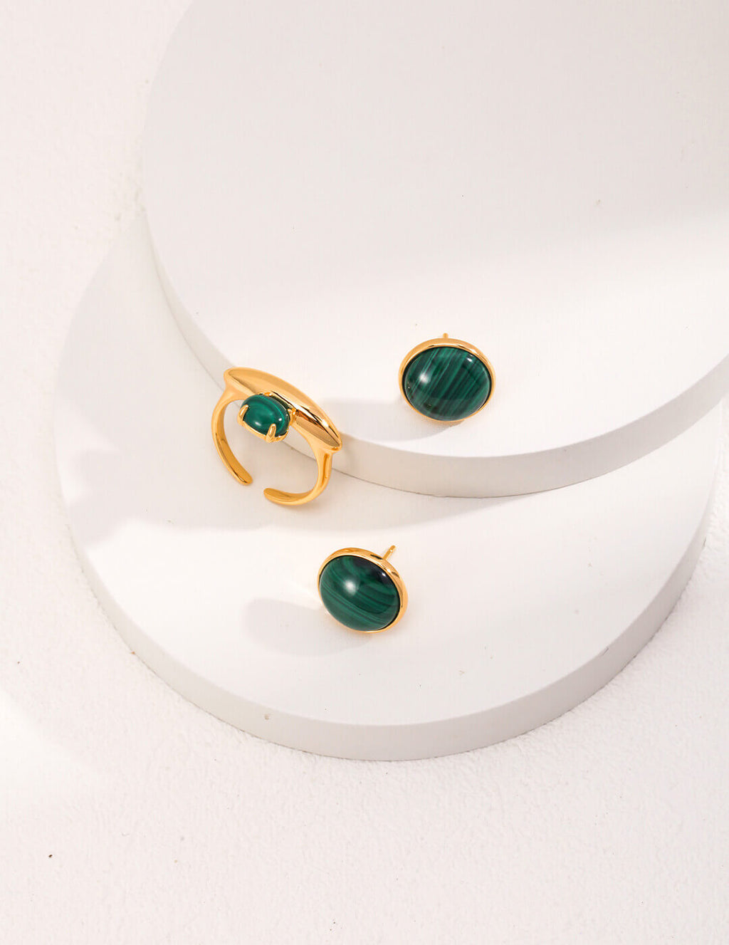 A single minimalist malachite stud earring, embodying simple and understated sophistication.