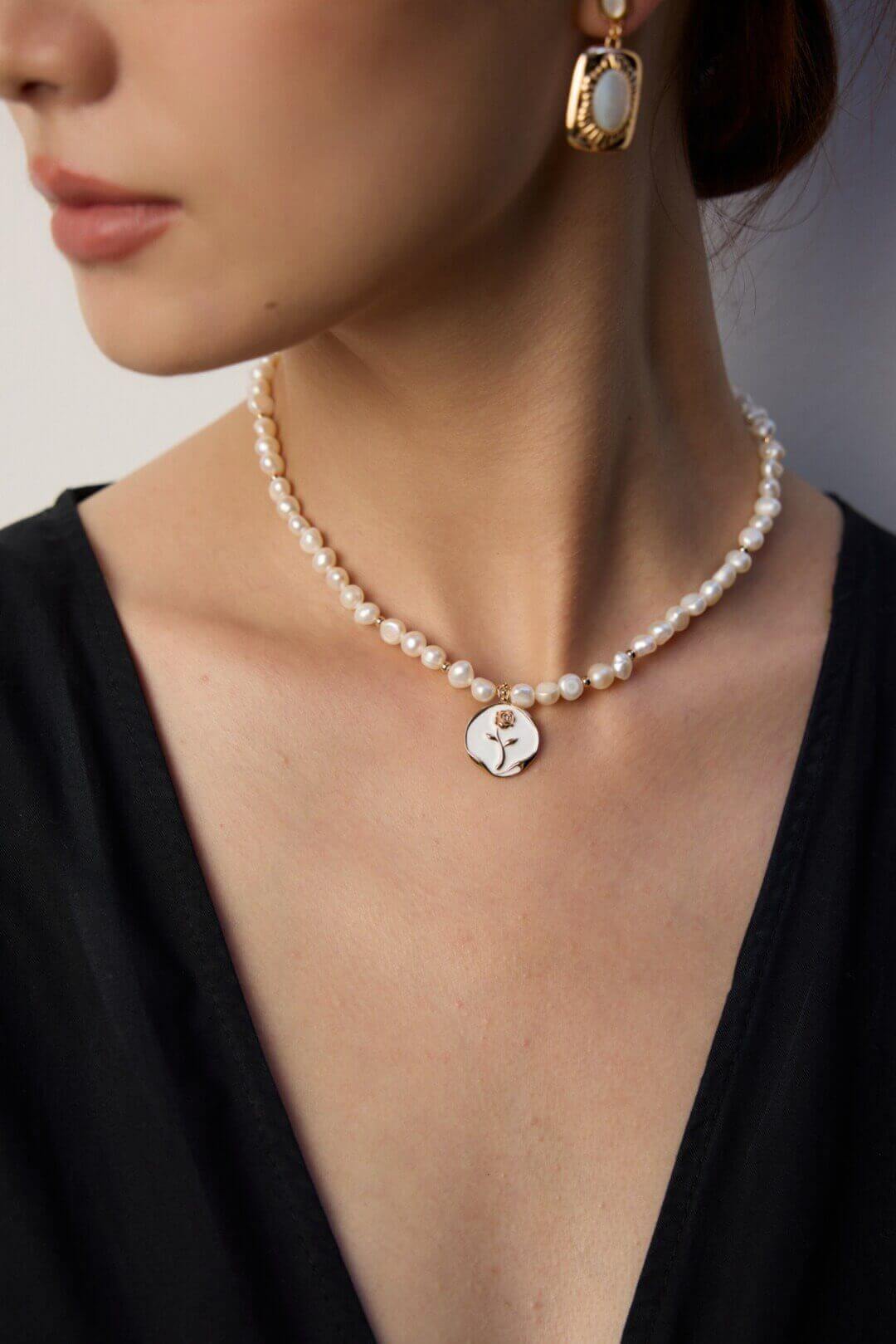 Simple yet elegant enamel rose necklace adding a touch of modern sophistication to a casual daytime outfit.
