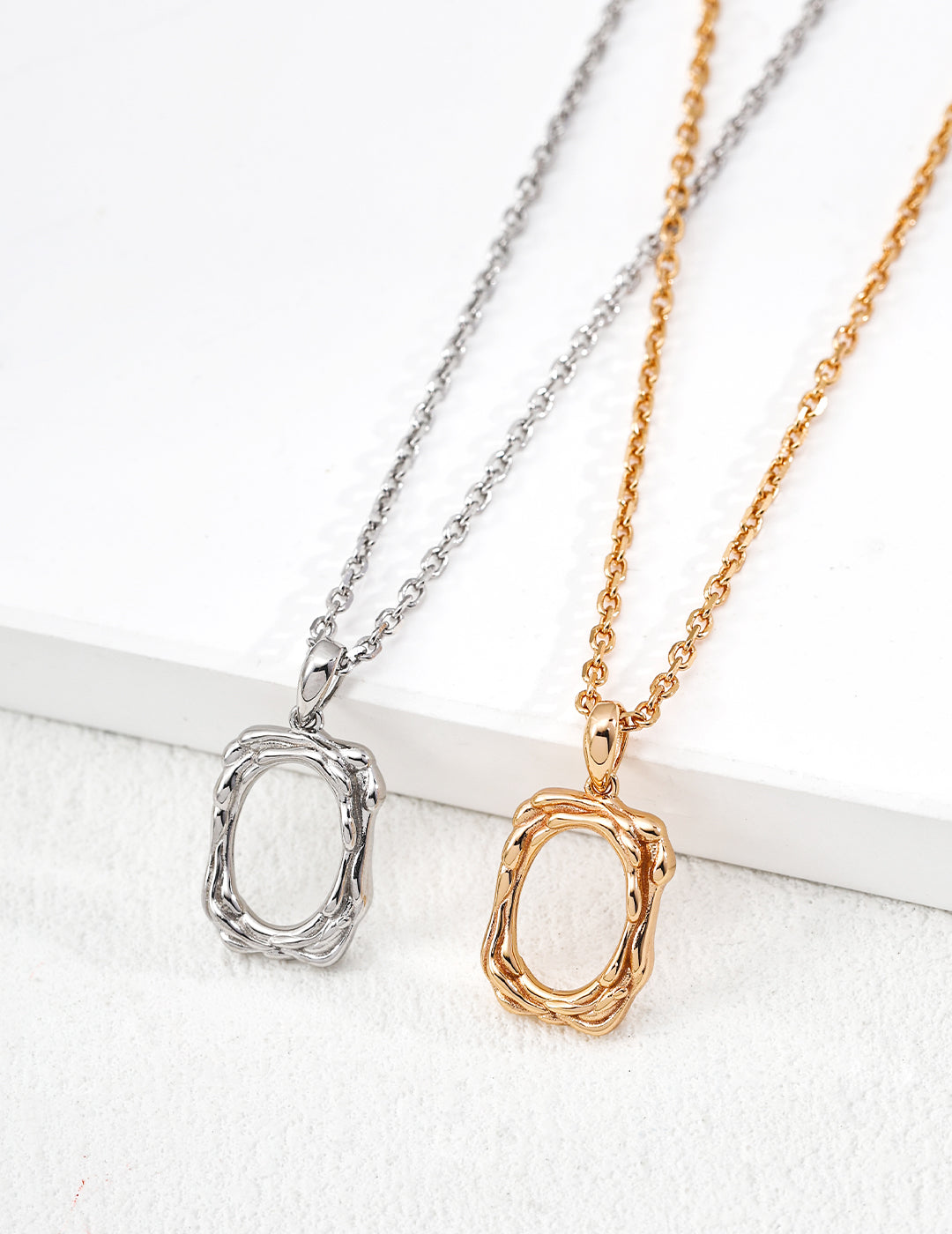 Two necklaces with unique pendants on a white background